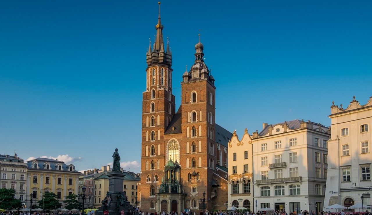 St. Mary's Basilica in Kraków, Poland, with its two distinct towers and Gothic architecture, surrounded by historic buildings in the main square.