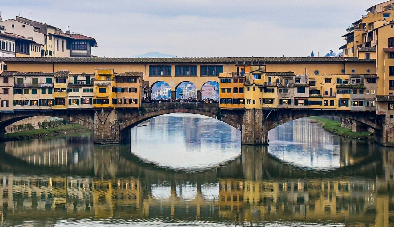 Sunset over Ponte Vecchio in Florence with golden river reflections