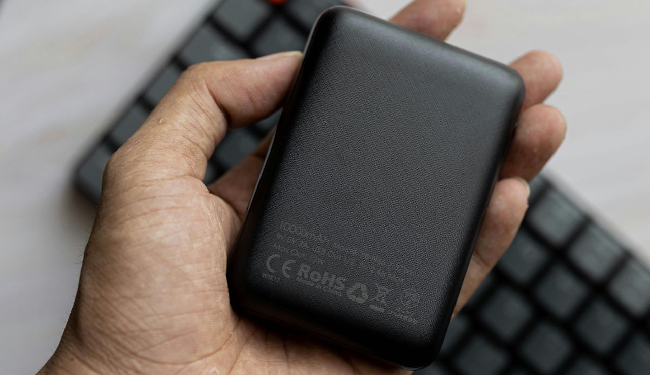 Portable phone charger next to travel items.