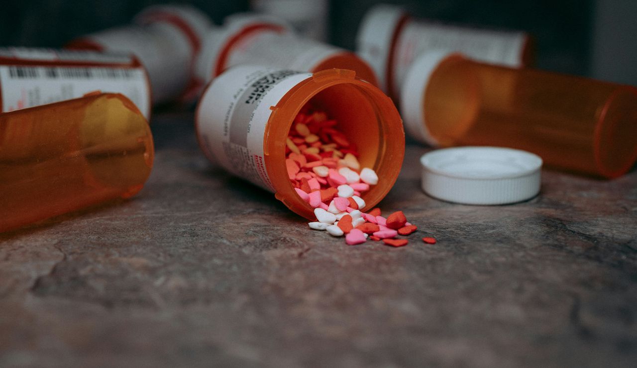 Spilled prescription bottle with colorful heart-shaped pills on a countertop.