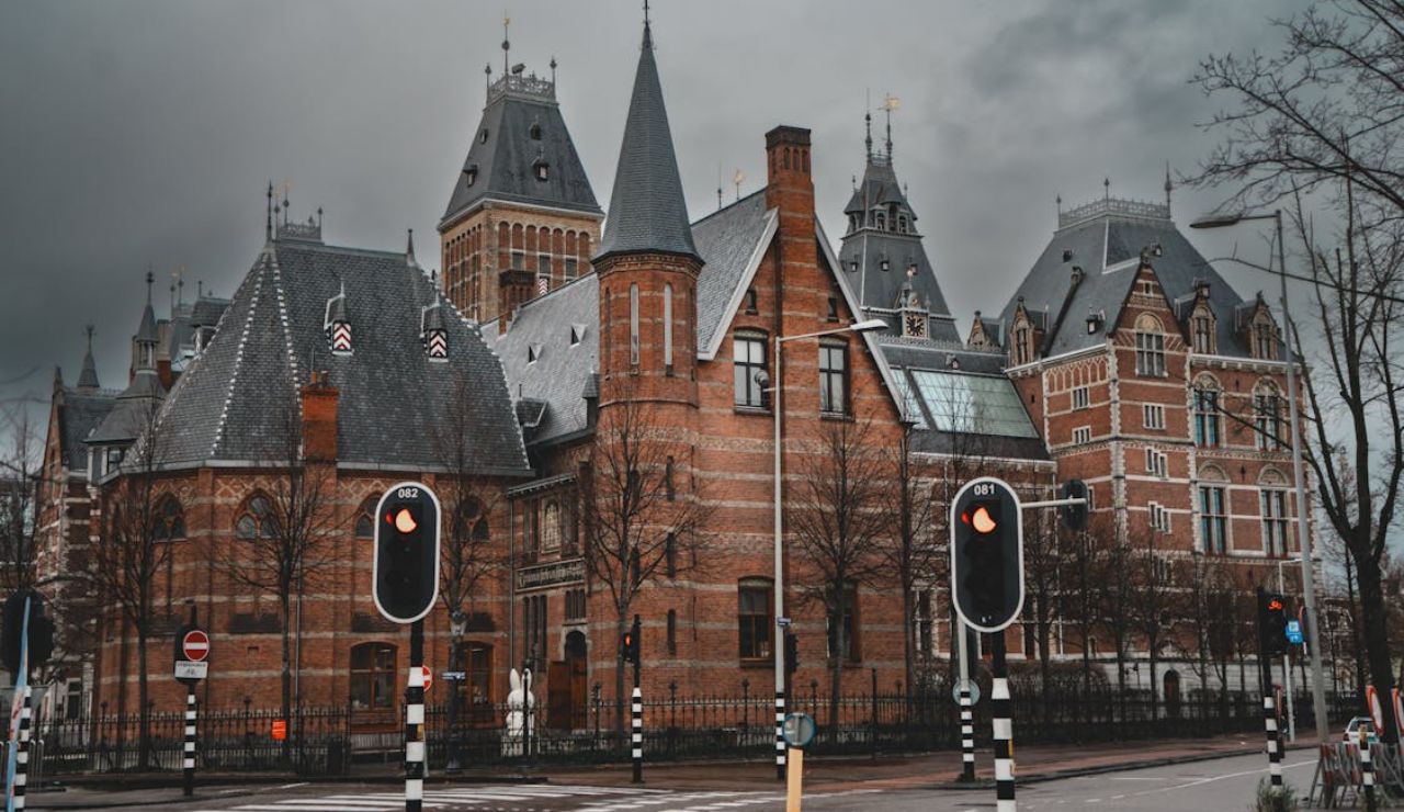 Historic building in Amsterdam under cloudy skies with empty streets, representing efforts to promote off-season travel.