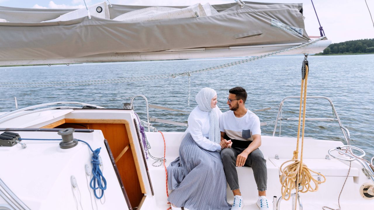 Couple sitting on the deck of a sailboat during sunset in Puget Sound