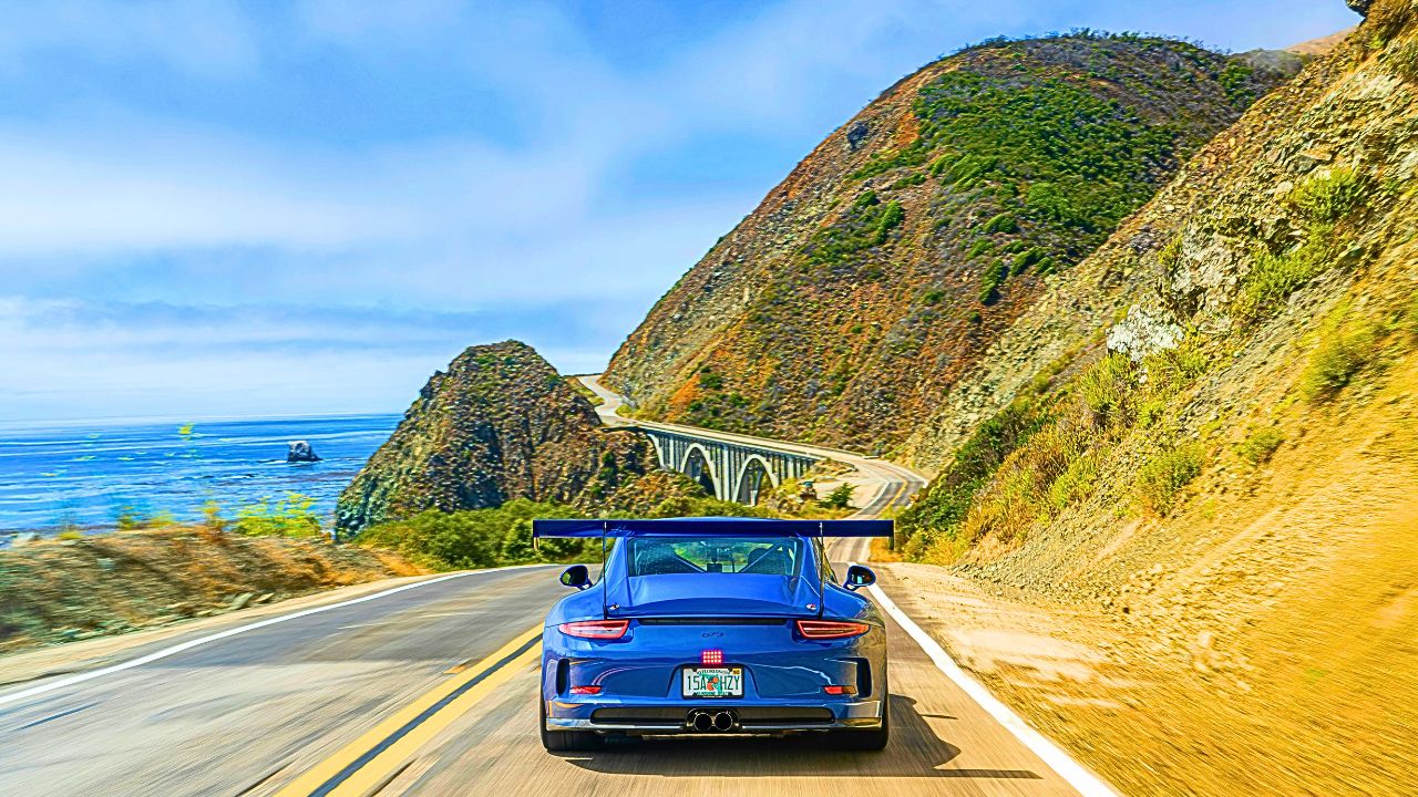 A car winding along the Highway with panoramic mountain views