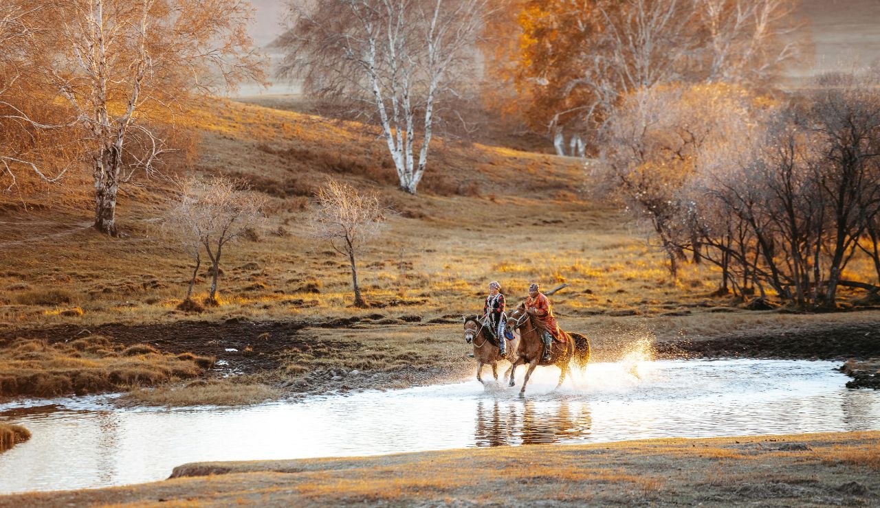 Horseback riders crossing a stream in the Montana foothills