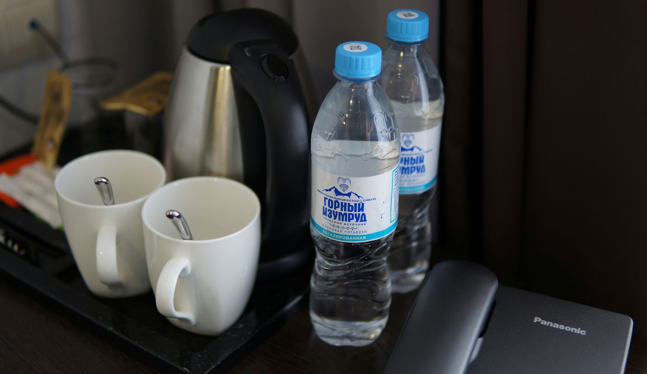 Refillable water bottle on airplane tray table for staying hydrated