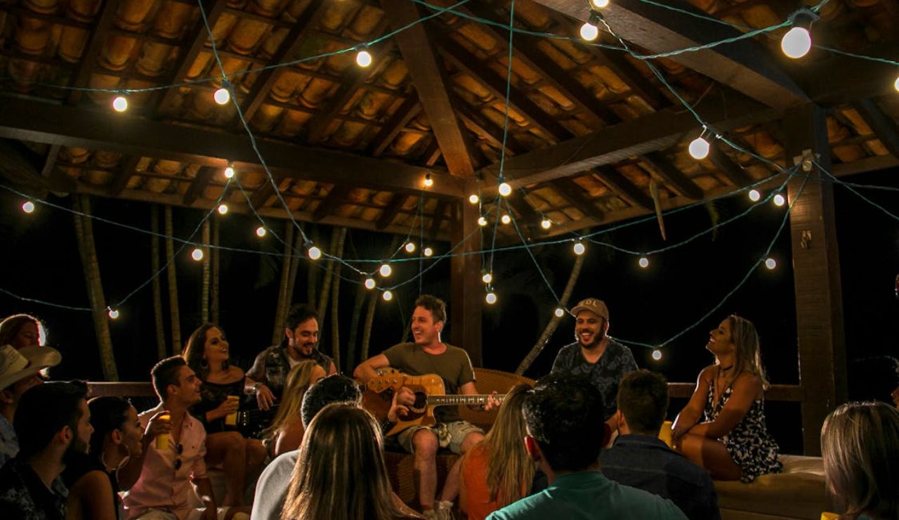 Group enjoying a lively night party with music and string lights, reflecting concerns over party tourism in Thailand.