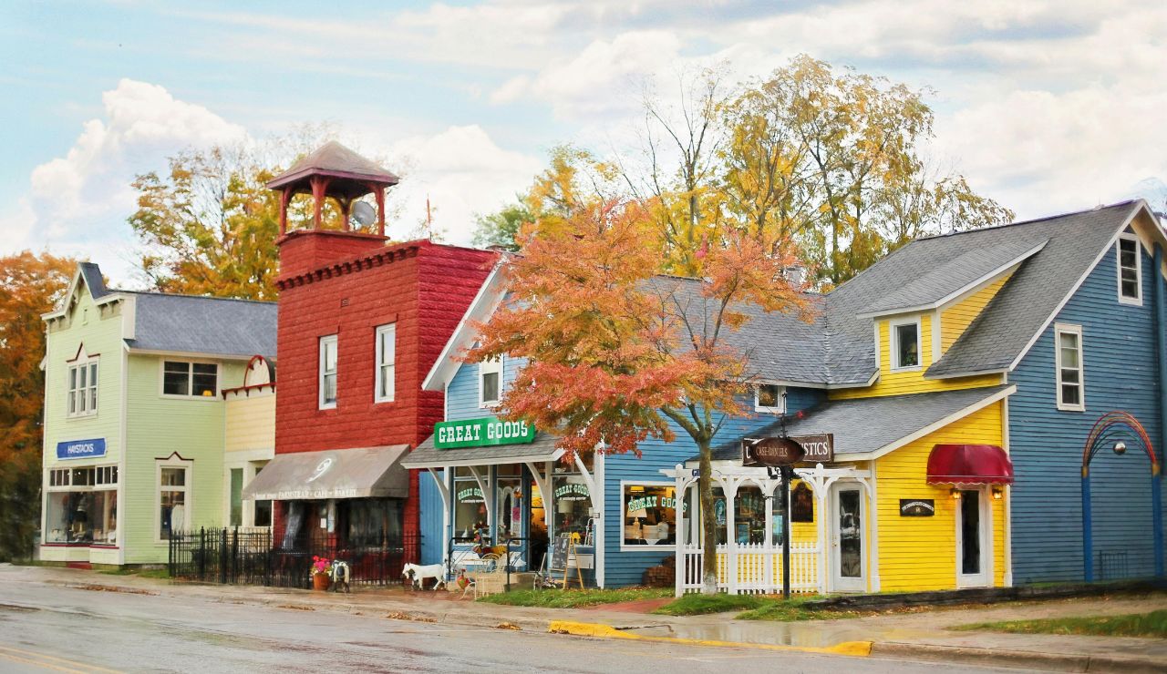 Tree-lined street with old buildings and boutique storefronts