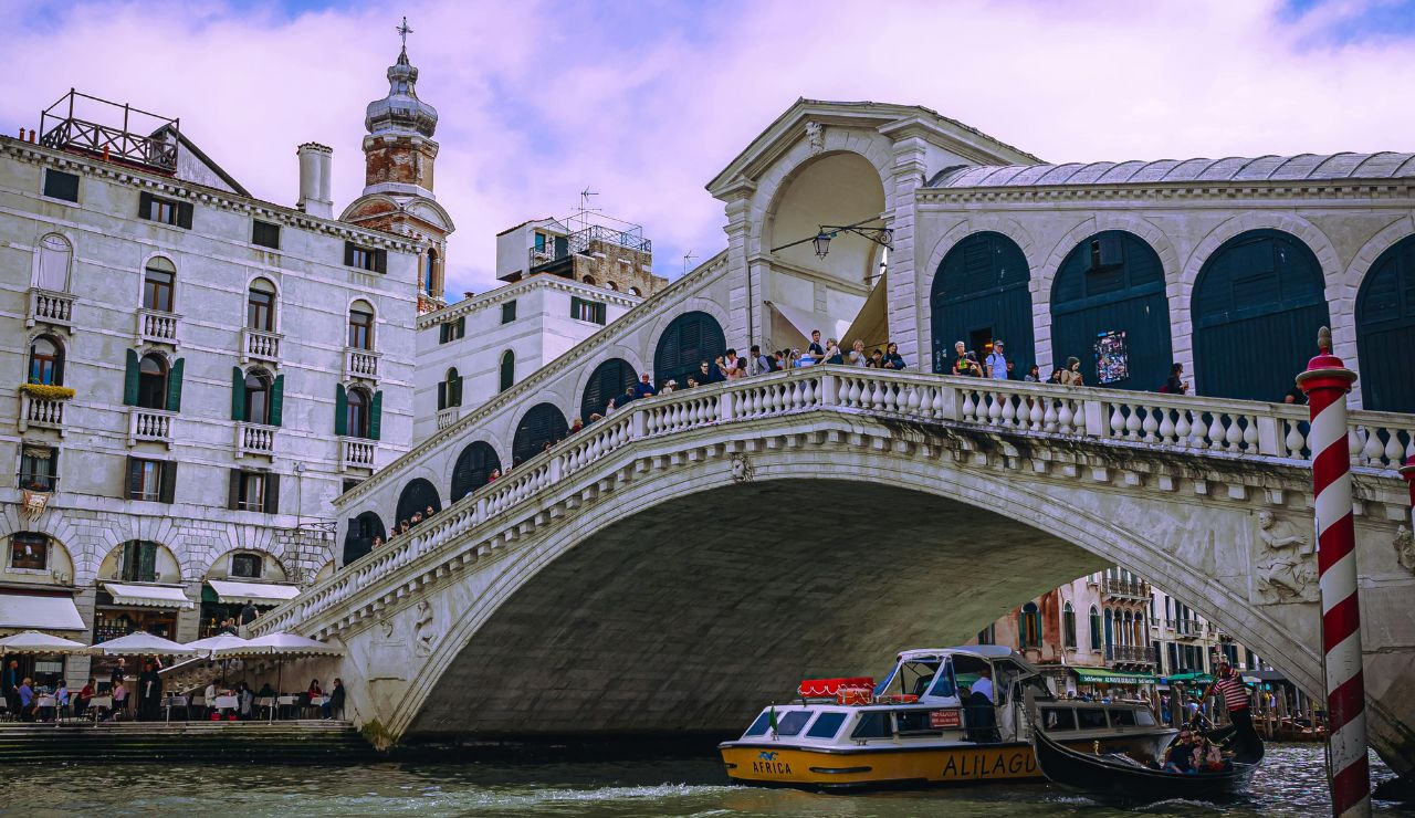 Rialto Bridge in Venice reflecting sunset over the Grand Canal