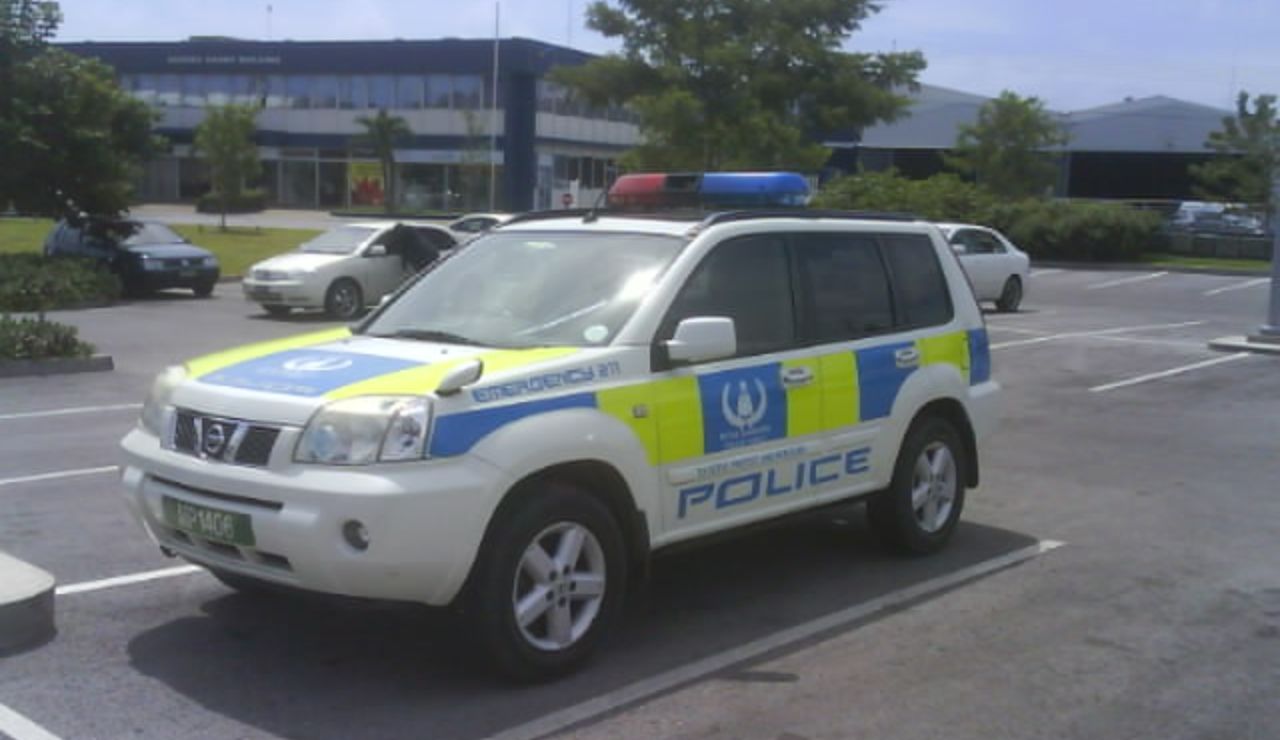 Police SUV parked in a lot, marked with blue and yellow decals and a red-blue light bar on top.