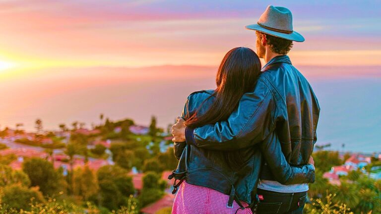 Couple watching sunset over the ocean at a San Diego cliffside