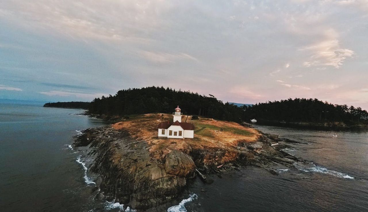 Lighthouse on a rocky coastline at sunset in the San Juan Islands, Washington.