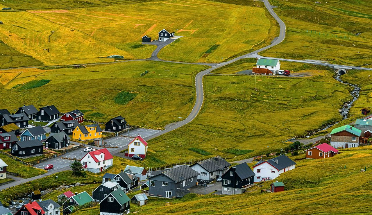 Green fields and turf-roofed homes on Sandoy Island, Faroe Islands