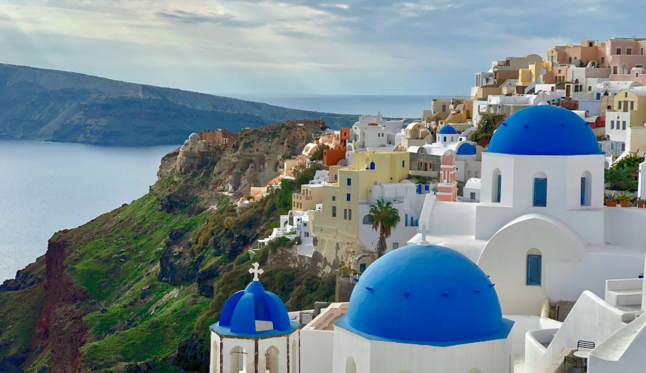 the sunset over whitewashed houses and blue-domed churches in Santorini.