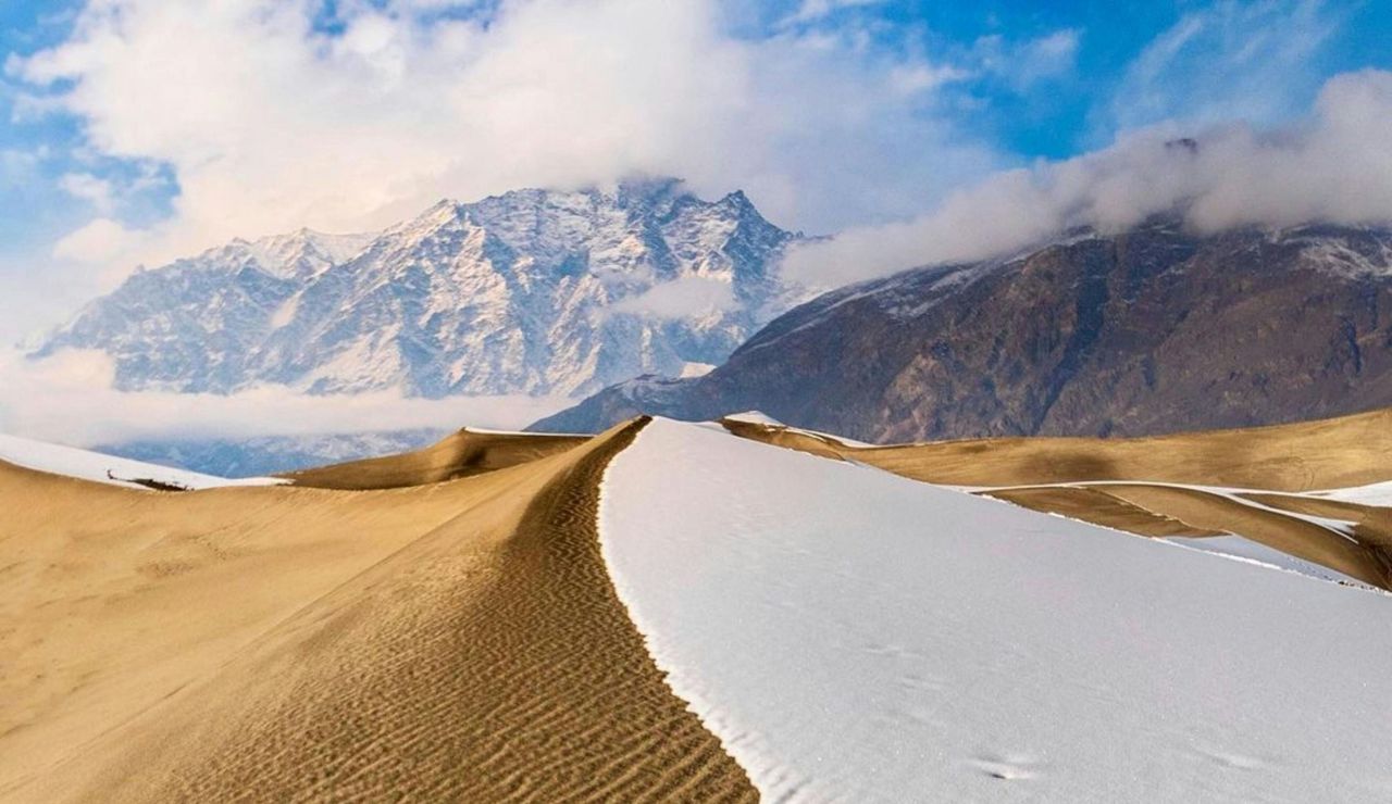Sand dunes with snowy mountains in Skardu Cold Desert