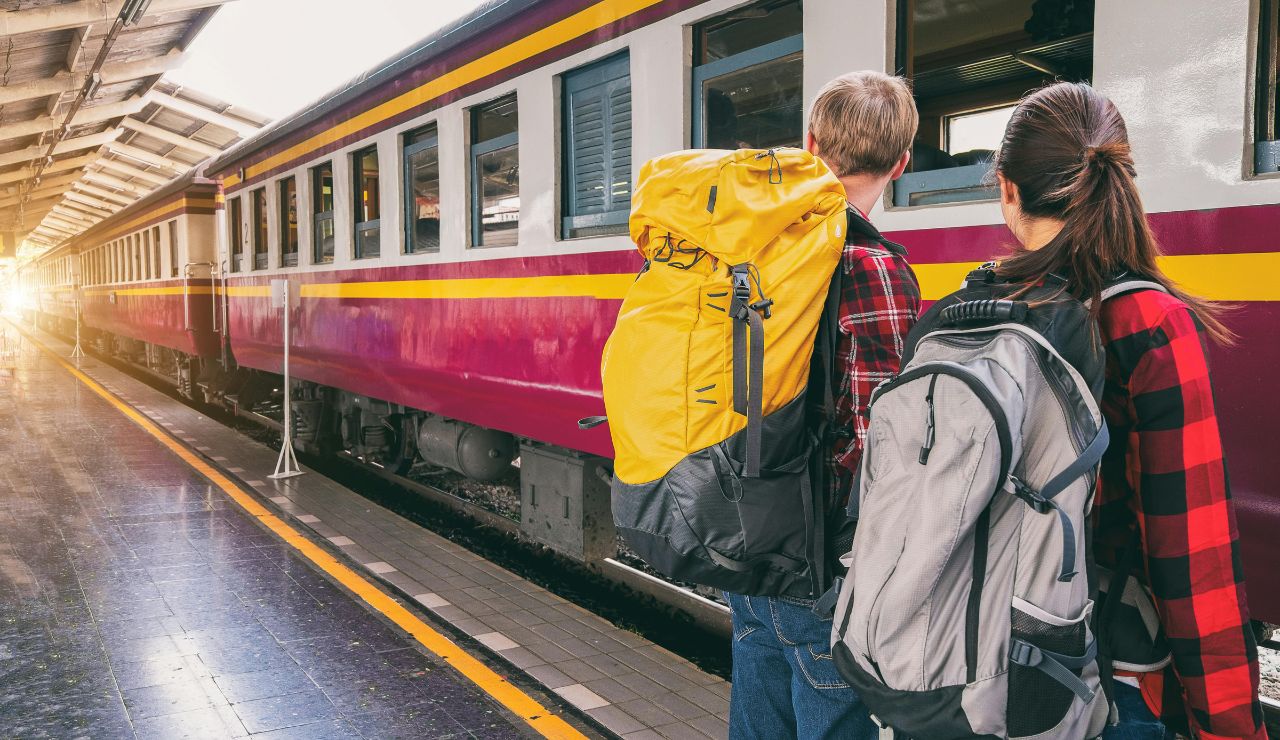 Two backpackers waiting to board a train at the station.