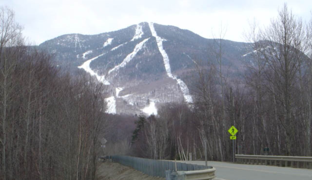 Scenic road near Smugglers’ Notch Loop in Vermont with mountain and ski trail views.