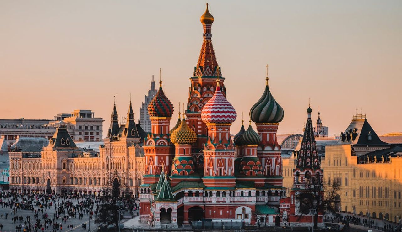 St. Basil's Cathedral in Moscow's Red Square at sunset with crowds nearby.