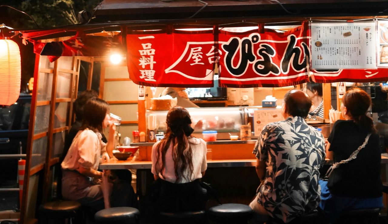 Tourist eating street food while seated in Tokyo, not walking