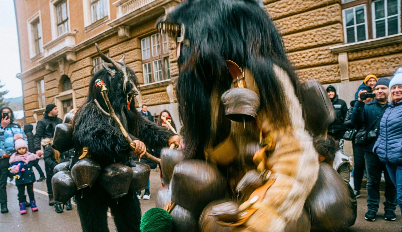 Participants in fur costumes and horned masks dancing around fire at Bulgaria’s Surva Festival