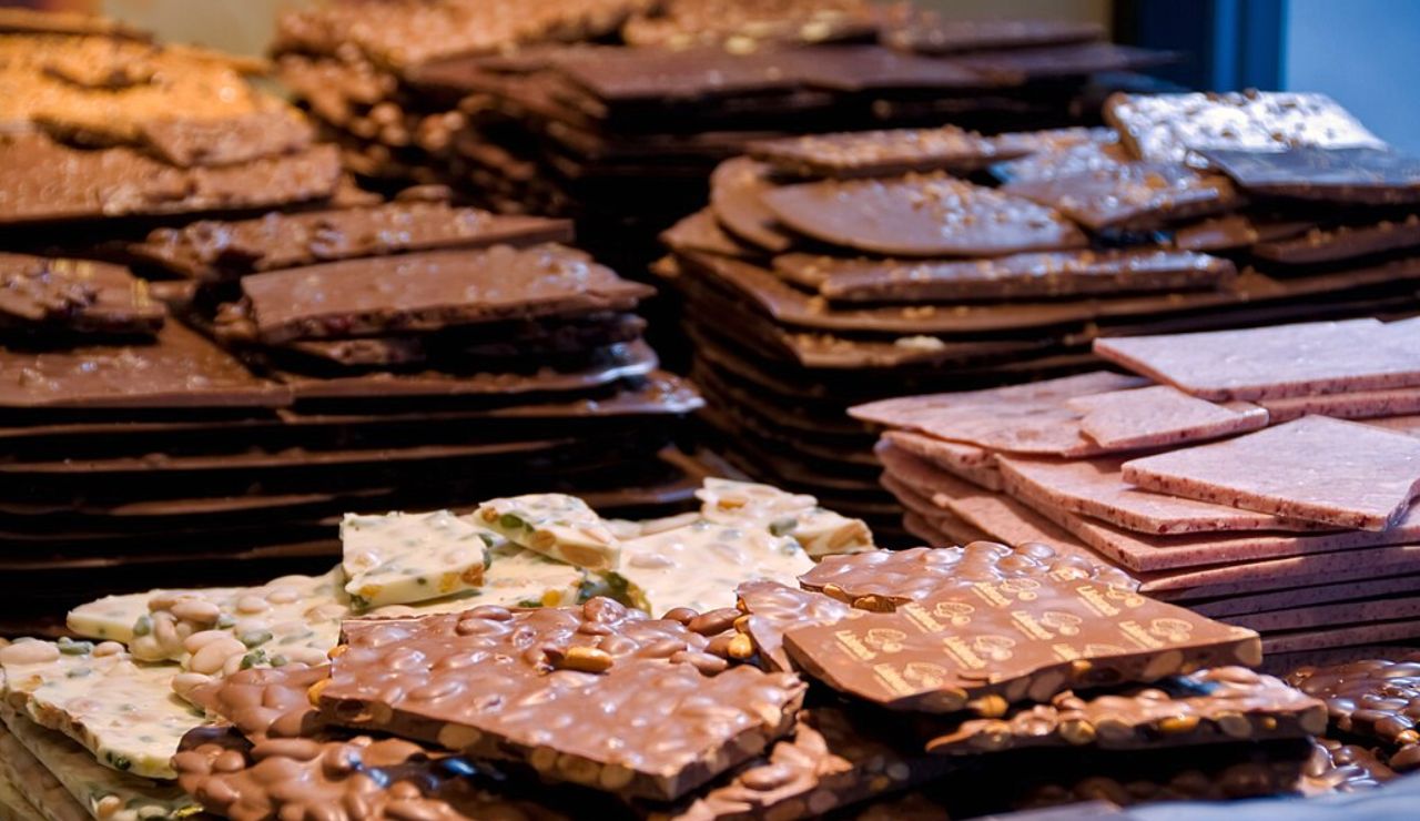 Stacks of assorted Swiss chocolate bars with nuts and fruit on display.