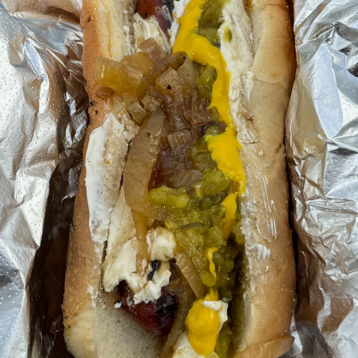 A grilled hot dog topped with cream cheese, grilled onions, relish, and mustard—Seattle's signature street food.