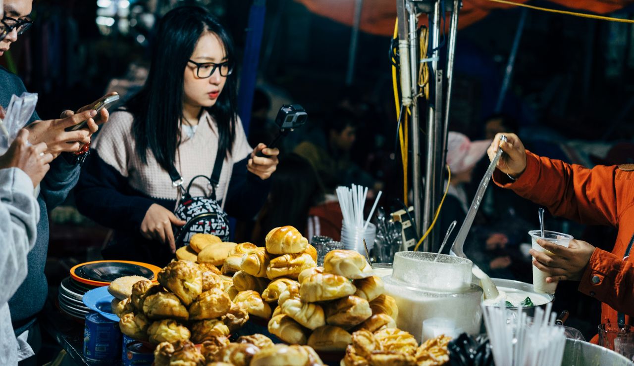 Traveler holding vibrant local street food with uncertain expression