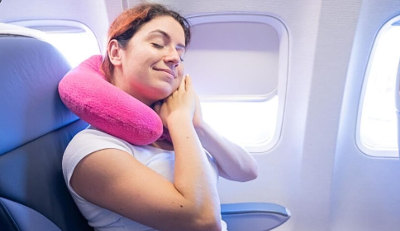 Traveler resting with a supportive memory foam neck pillow on a flight.