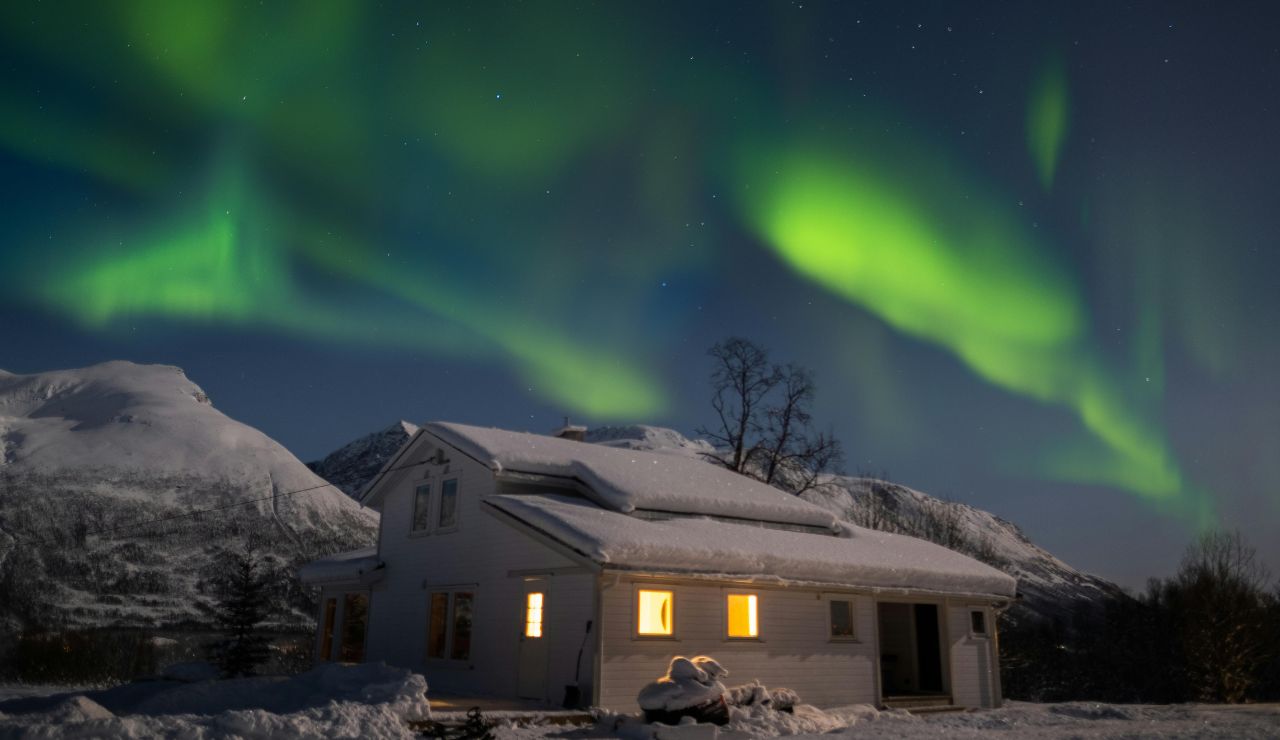 Northern lights above snow-covered mountains in Tromsø