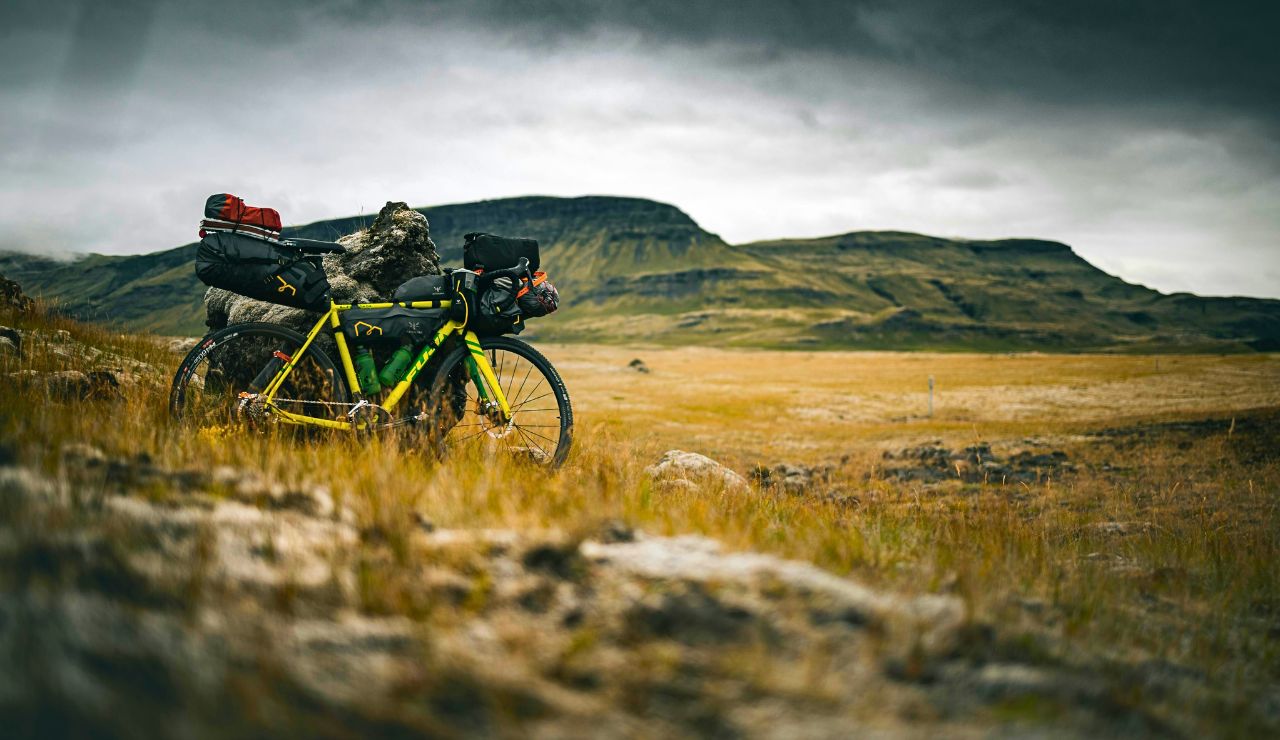 Rider pushing bike through red rock canyon in Twentymile Wash
