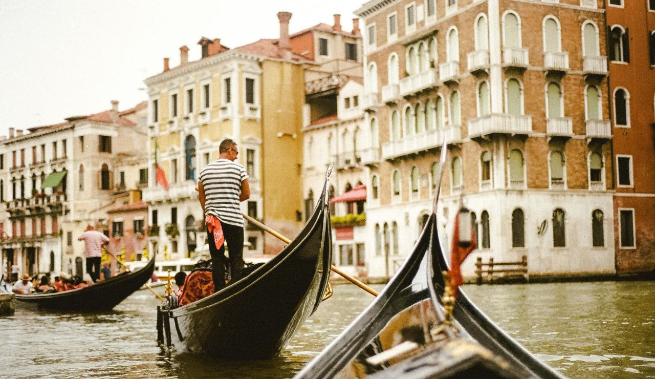Gondola floating on canal with historic buildings in Venice