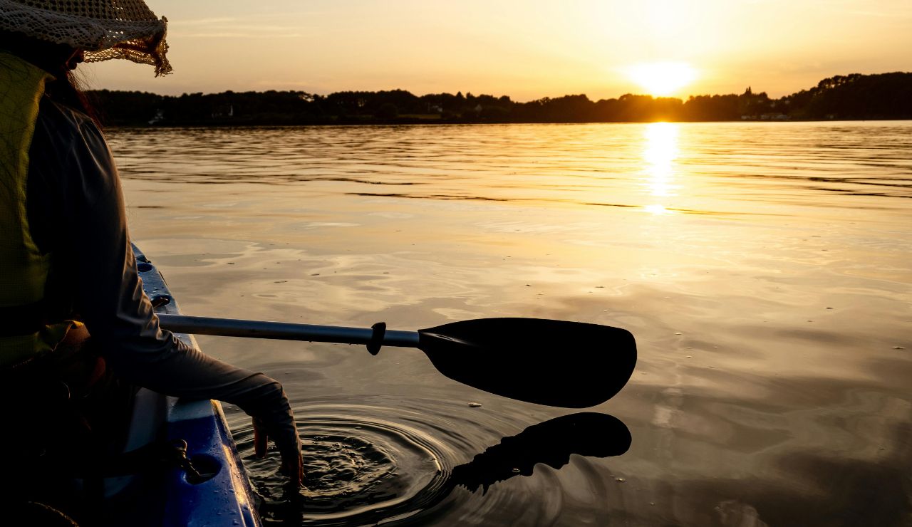 Kayaker paddling through glowing bioluminescent water in Vieques
