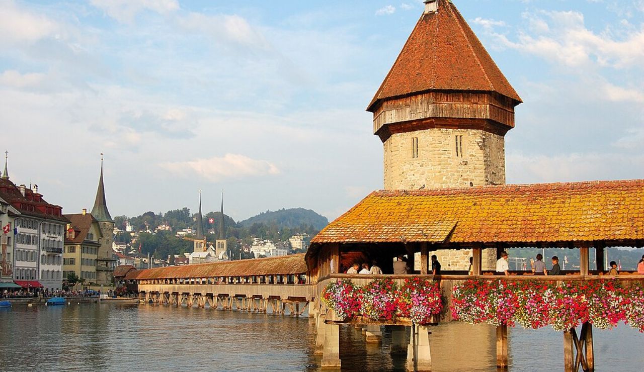 Chapel Bridge and Water Tower in Lucerne decorated with vibrant flowers.