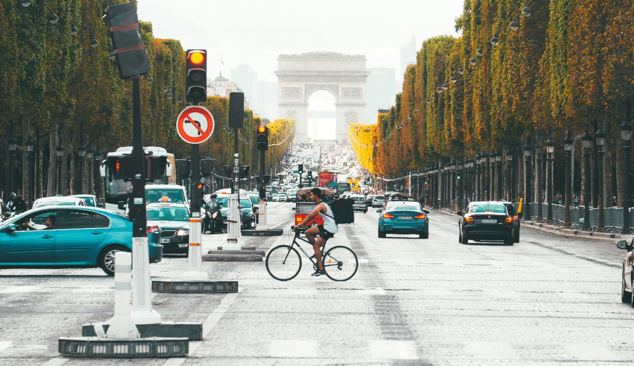 A traveler observing pedestrians, signs, and traffic on a busy street.