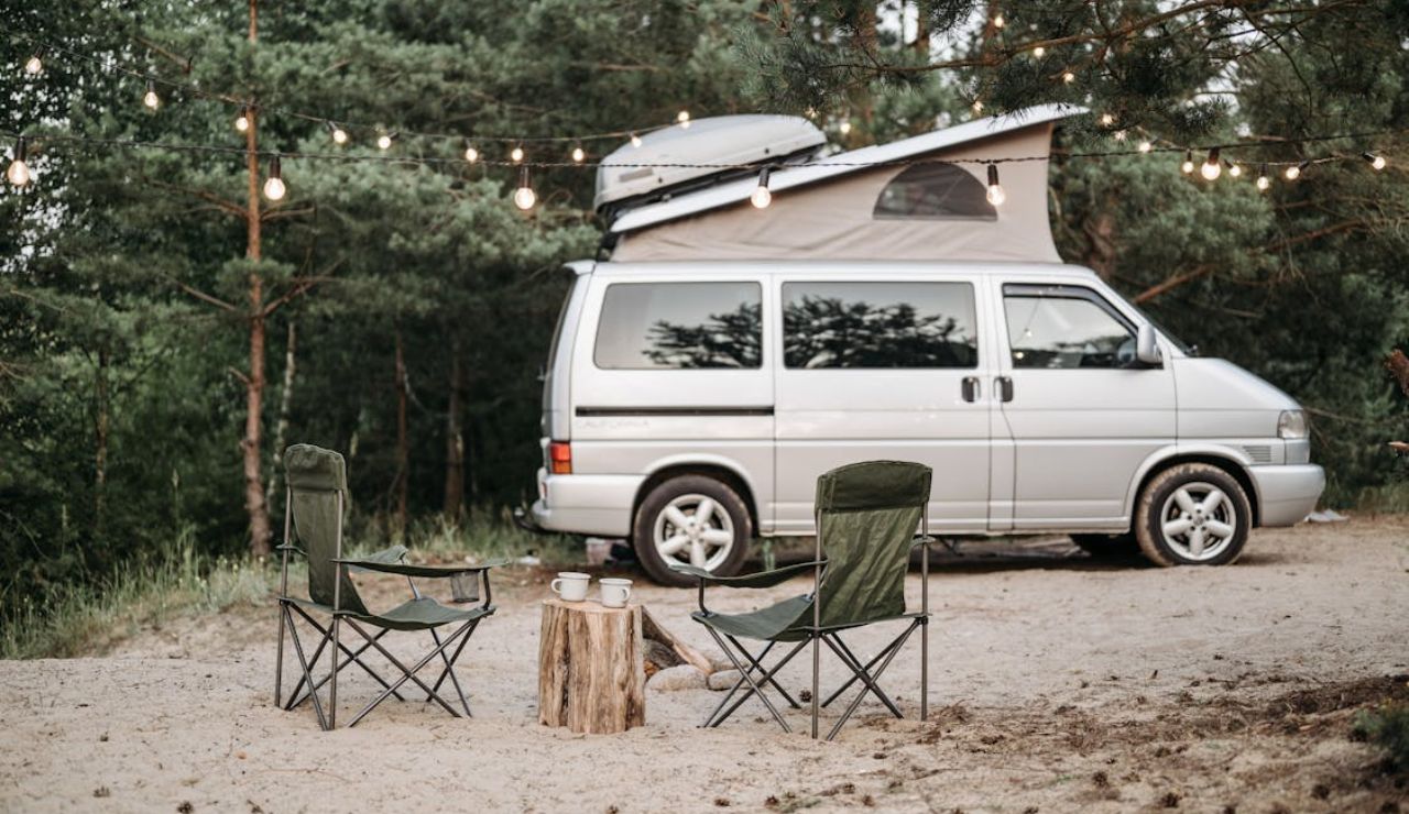 Camper van and chairs under string lights, showing daily outdoor weather planning.