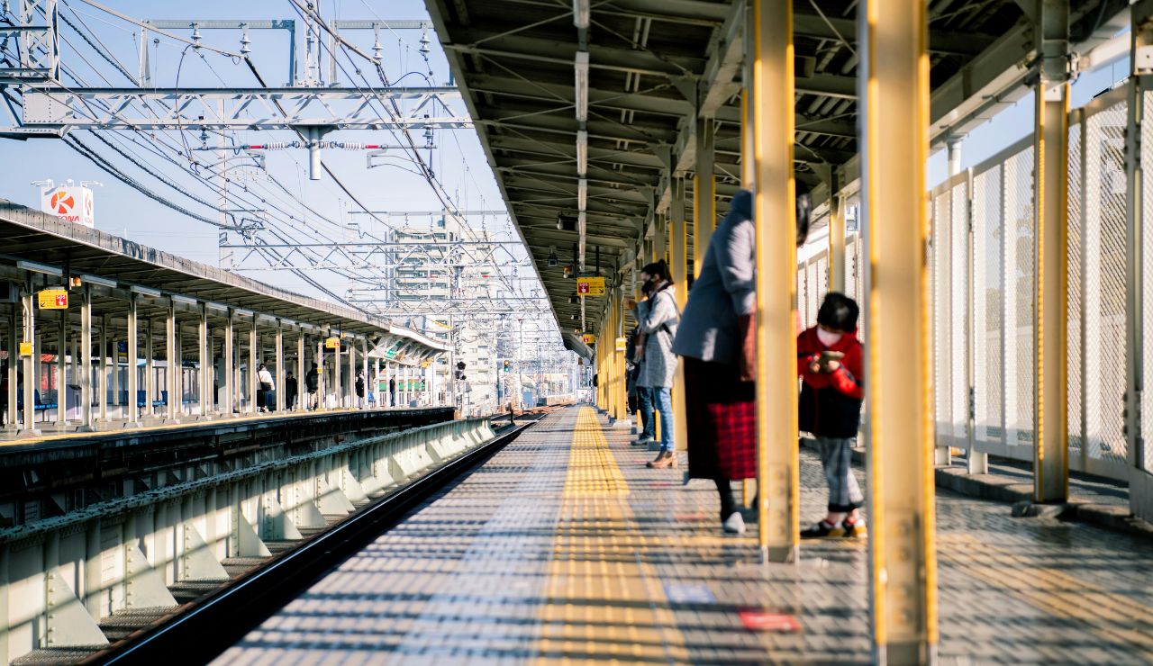 Spotless train station platform in Japan with people waiting respectfully.