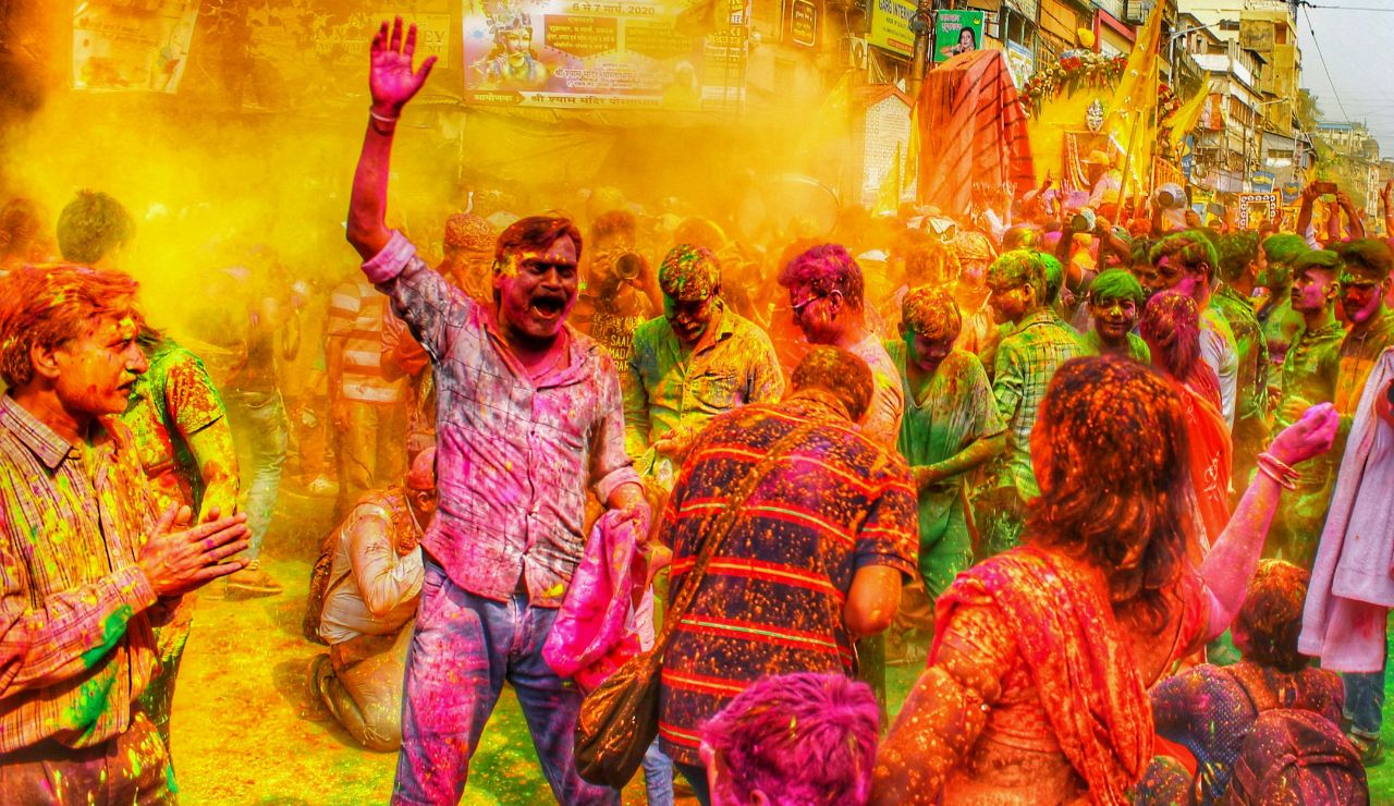 People covered in colorful powders celebrating Holi in India.