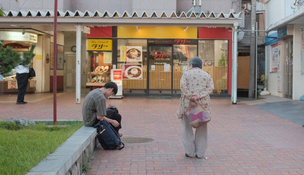 A person being quietly observed after littering on a clean Japanese street.