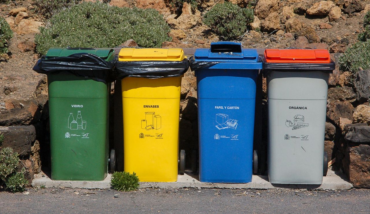 Color-coded recycling bins with detailed labels in a Japanese residential area.