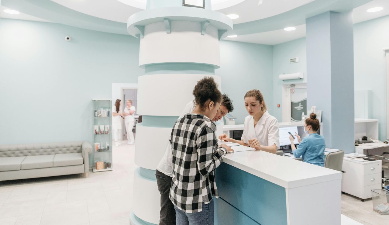 An American traveler in a foreign hospital appearing overwhelmed by forms or language issues.
