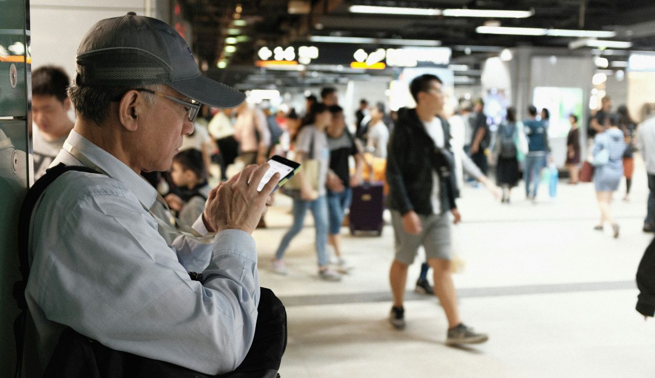 Traveler checking a busy or sold-out train timetable at station