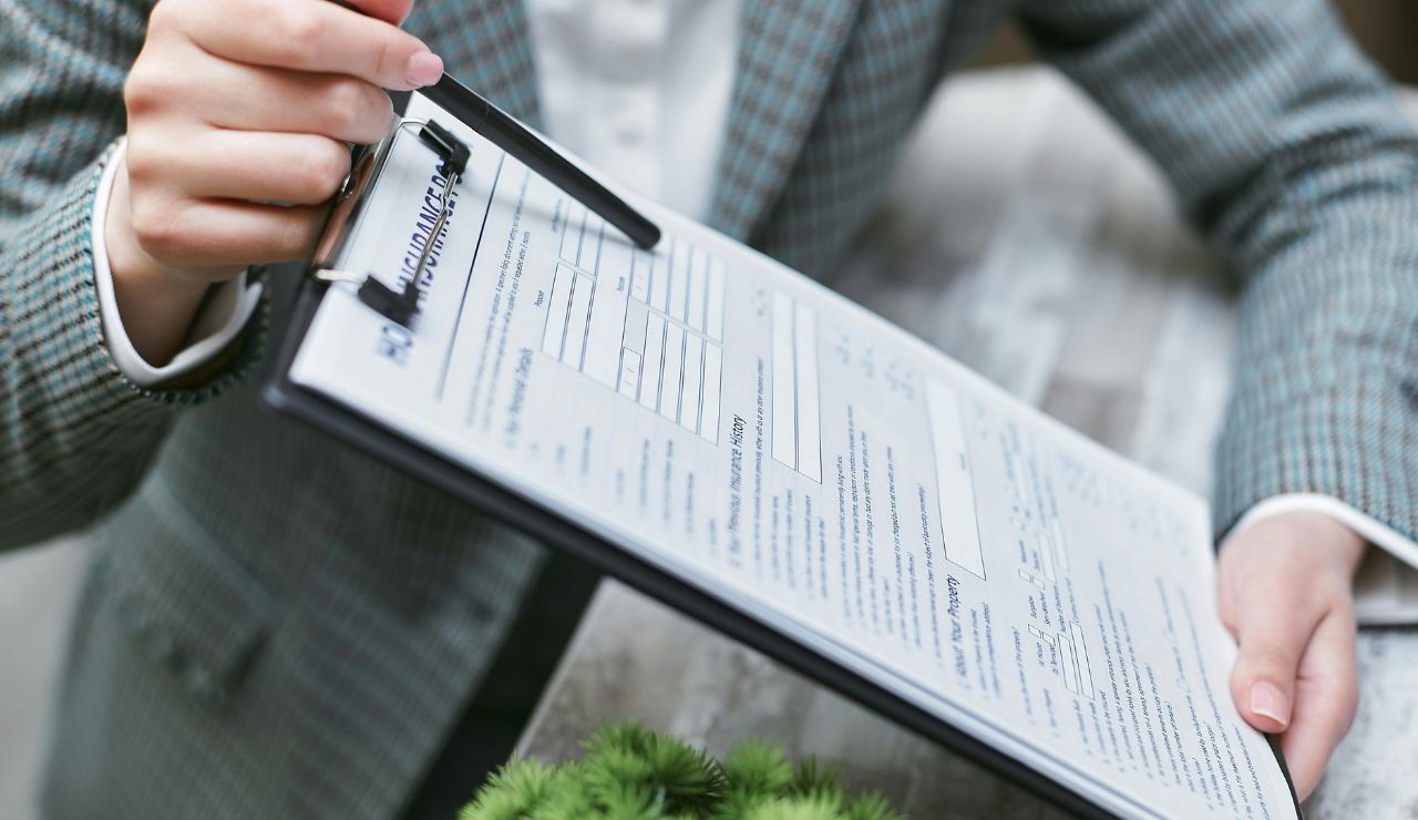 Close-up of a traveler reading insurance documents with a confused or doubtful expression.