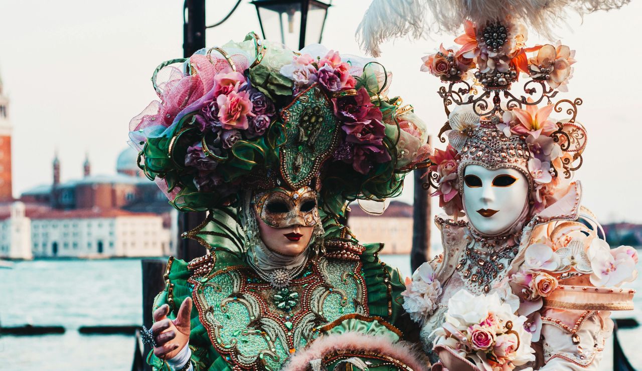 Costumed people in elaborate masks at Venice Carnival.