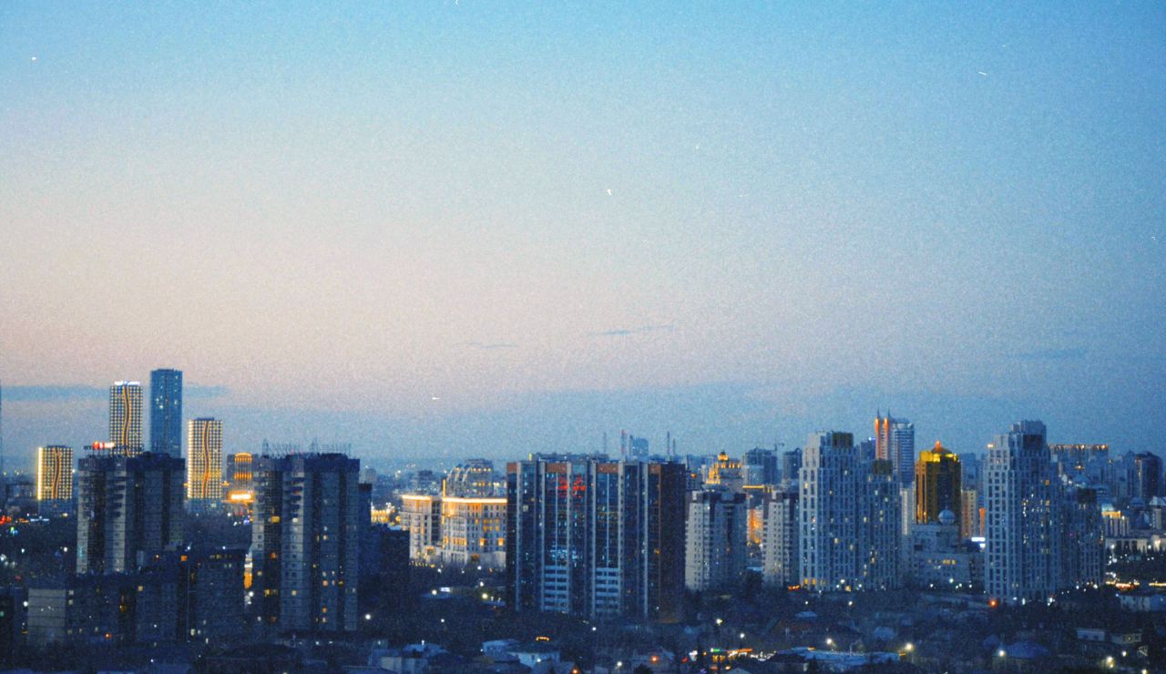 Cityscape view of Almaty with modern buildings and scenic surroundings.