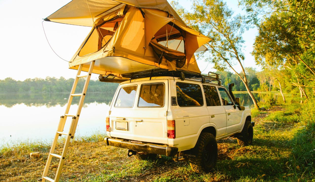 Mid-size Class C RV parked by a lake with a scenic view