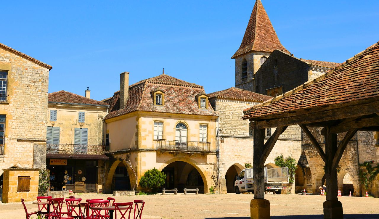 Red sandstone buildings under blue sky in a charming, quiet French village