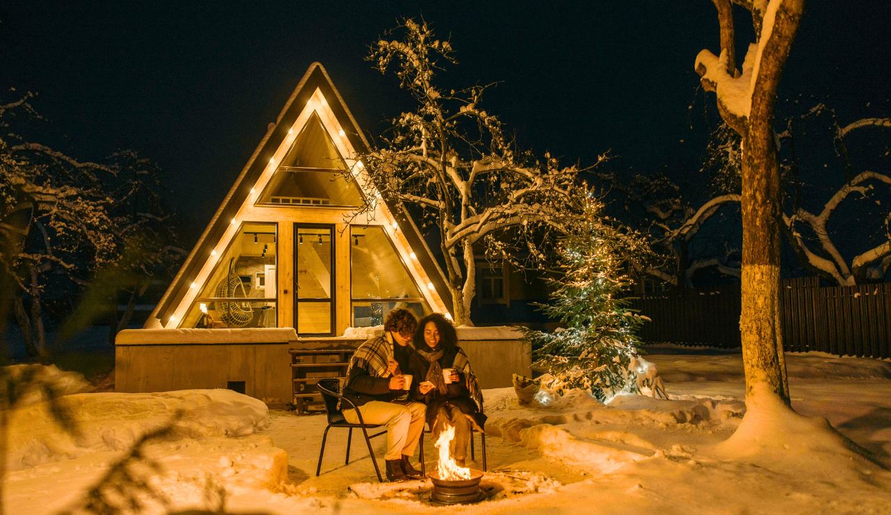 Couple enjoying a campfire outside their RV under the stars