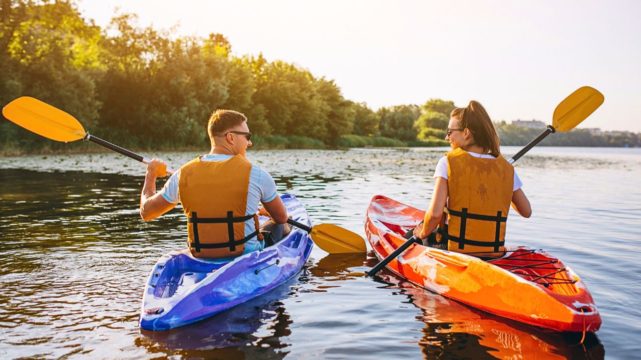 Couple kayaking toward a quiet river island.