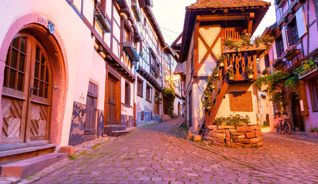 : Circular street with colorful half-timbered houses and lush flower arrangements