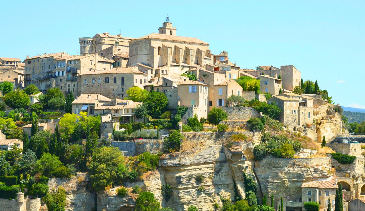 Hilltop village with stone buildings overlooking a lavender-filled valley