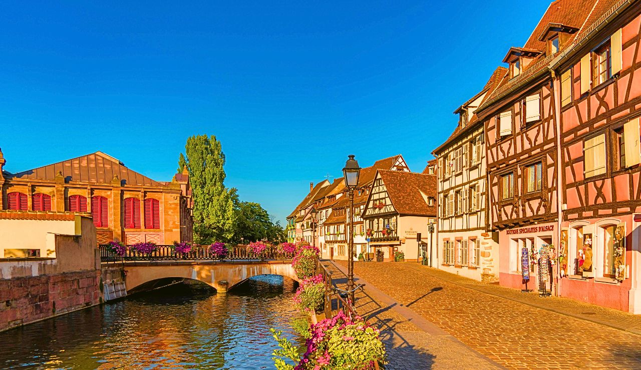 Cobblestone street lined with timber-framed houses and flower boxes in a French village